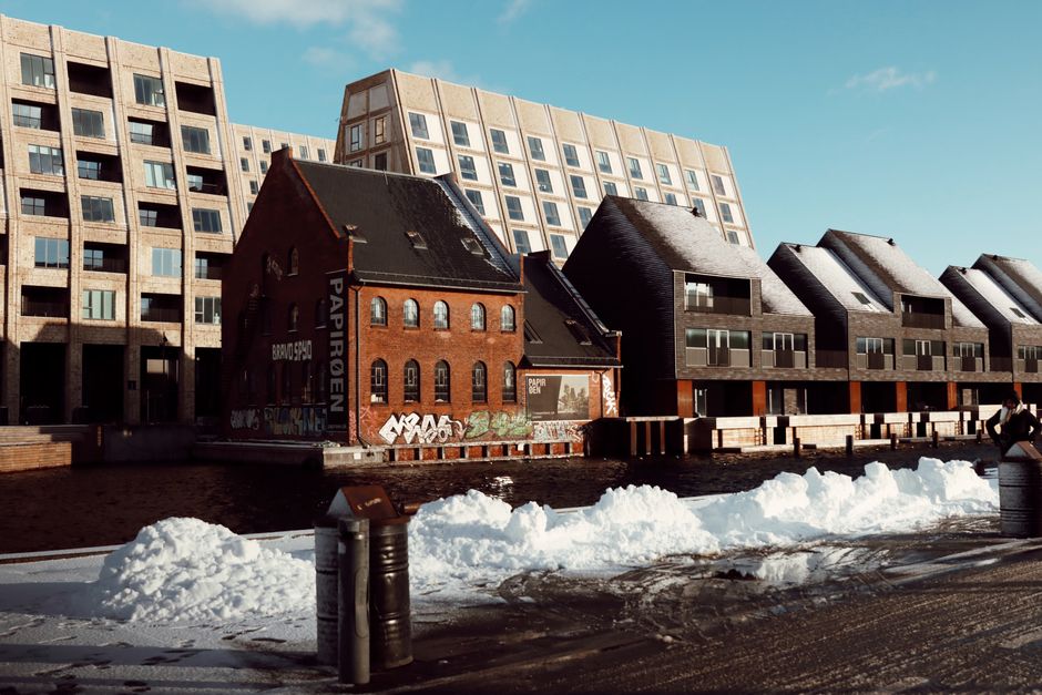 Snow-covered architecture in Copenhagen's Nyhavn Canal showcasing modern and traditional styles.