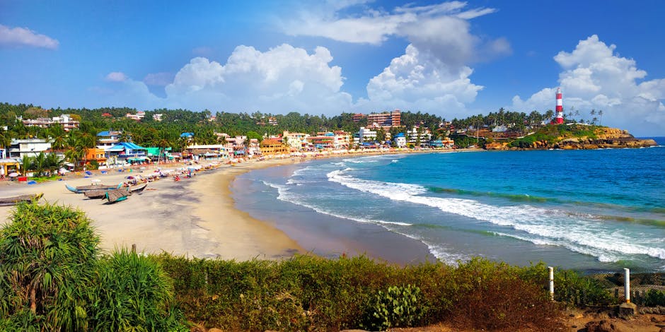 Beautiful view of Kovalam Beach, India featuring a vibrant town and iconic lighthouse.