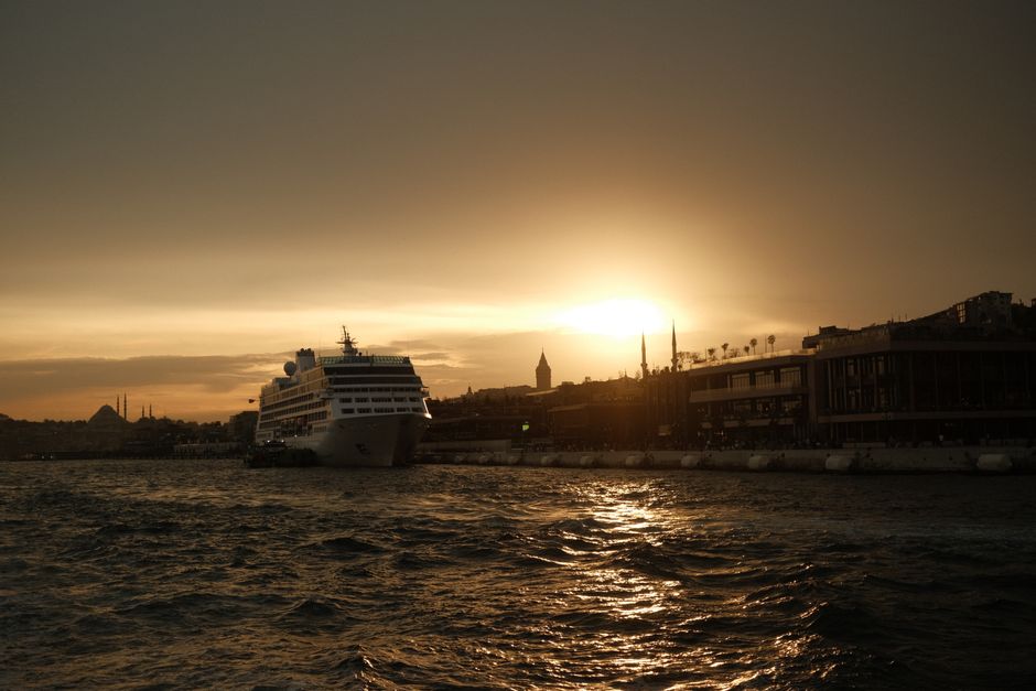 Discover a stunning view of a cruise ship at Istanbul harbor during a breathtaking sunset.