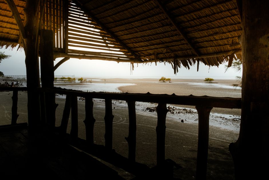 View from a traditional Malaysian hut in Tanjong Sepat, framed by mangrove trees and beach.