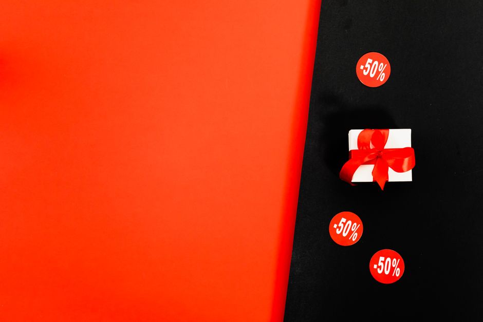 Shop 50% discounts with a stylish gift box on a Black Friday sale background.