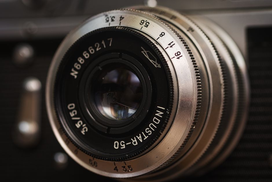 Detailed close-up of a vintage camera lens with metal rings and engraved numbers.