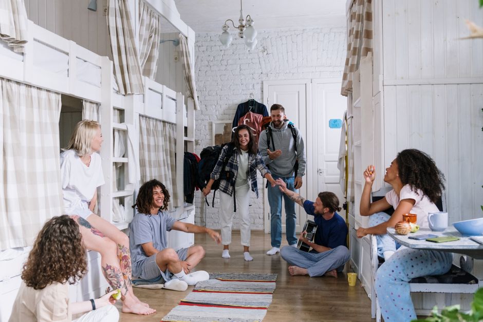 A diverse group of friends enjoying each other's company in a cozy dorm room, creating a warm and vibrant atmosphere.