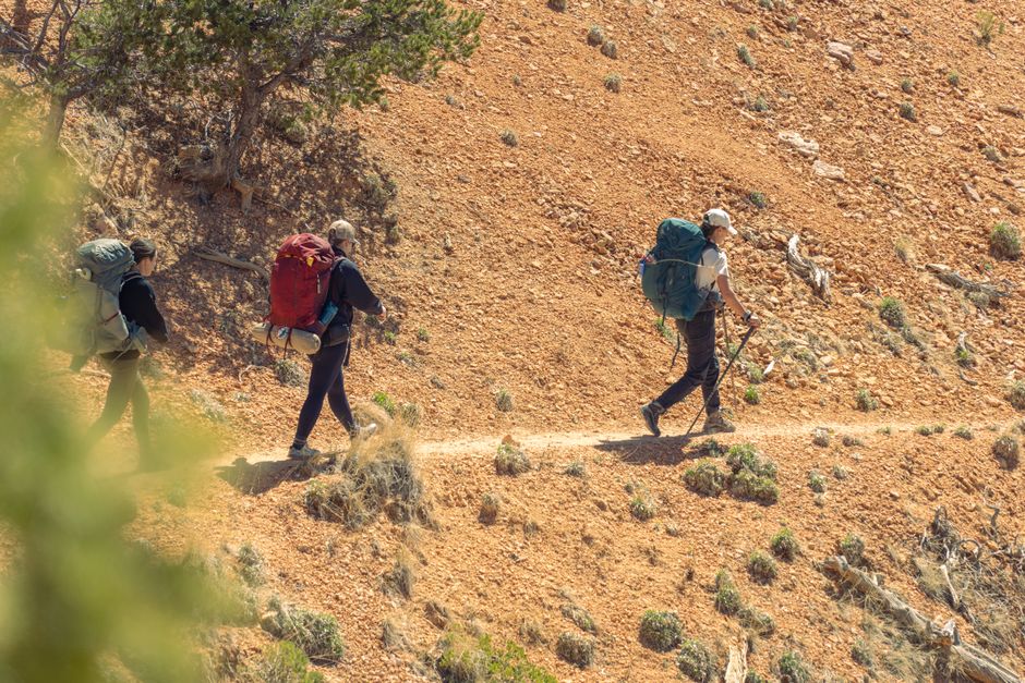 Three hikers traverse the rocky trails of Bryce Canyon National Park, showcasing adventure in Utah's natural beauty.