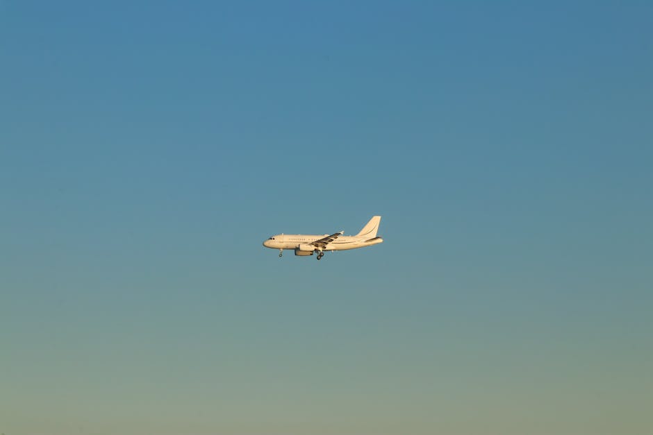 A commercial airplane flying against a clear blue sky during the day in Istanbul.