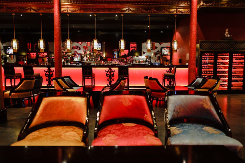 Luxurious and vibrant Asian-inspired restaurant interior with colorful chairs and ambient lighting.
