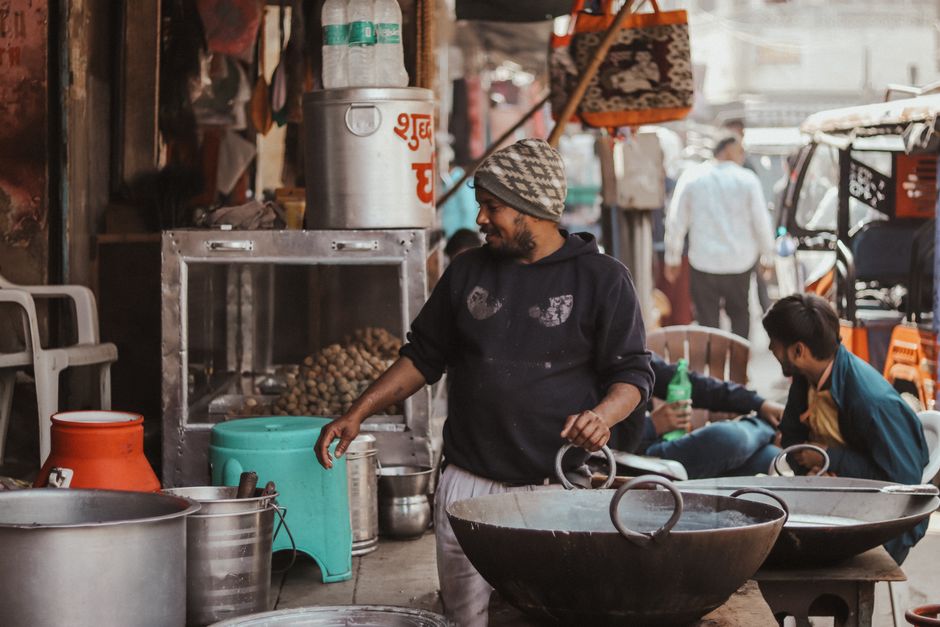 A street vendor preparing traditional food in a bustling Indian market.