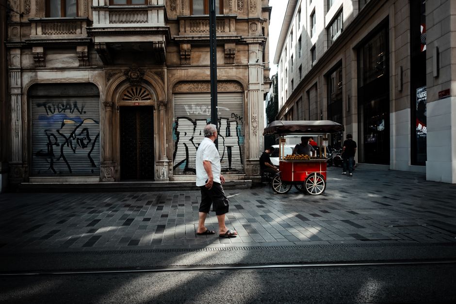 Vibrant street scene on İstiklal Avenue, Istanbul, featuring a red cart and pedestrians.