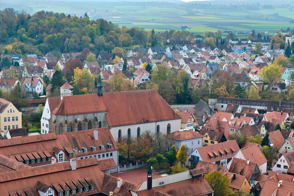 A beautiful aerial view of Nördlingen, Bavaria, showcasing red-roofed buildings and autumn foliage.
